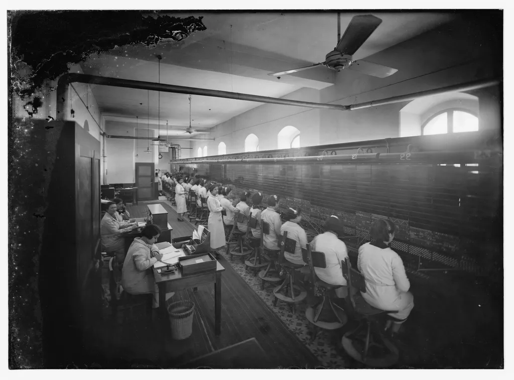 An old telephone switchboard with rows of patch cables and dials, photographed straight on